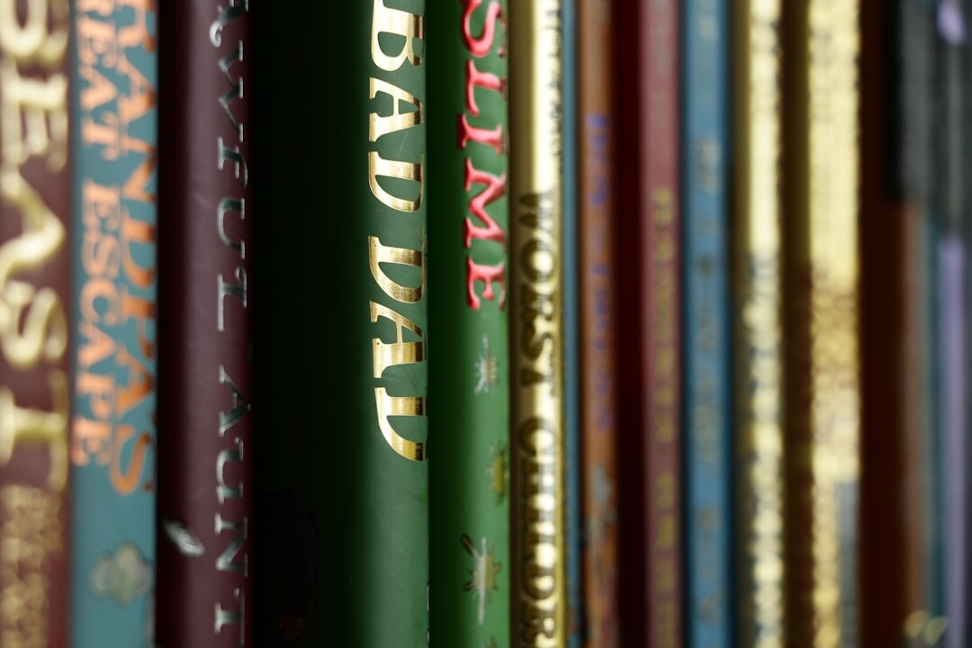 Rows of old books on a wooden library shelf